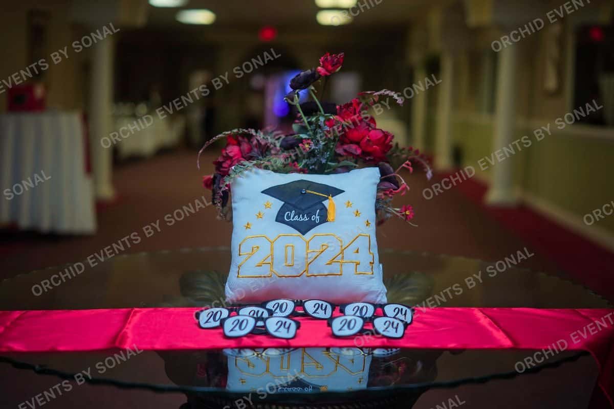 Class of 2024 cushion centrepiece on a mirrored table with a floral arrangement
