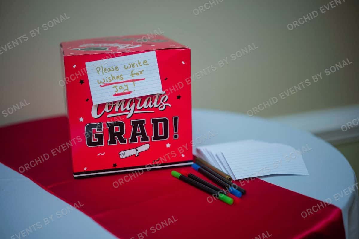 Congrats Grad wishes box and note cards on a red table runner